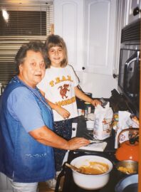 Thelma Granquist in kitchen, teaching granddaughter Emma how to bake